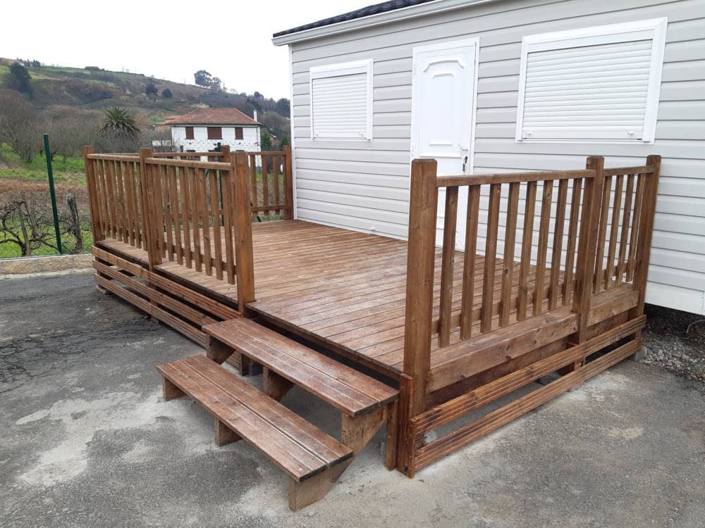 Terraza de madera sin cubrir con barandilla y escalones